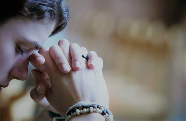 mujer-orando-con-ojos-cerrados-pulsera-con-rosario-en-mano-020817